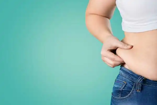 Image of woman pinching her love handles to show weight gain Newcastle under Lyme